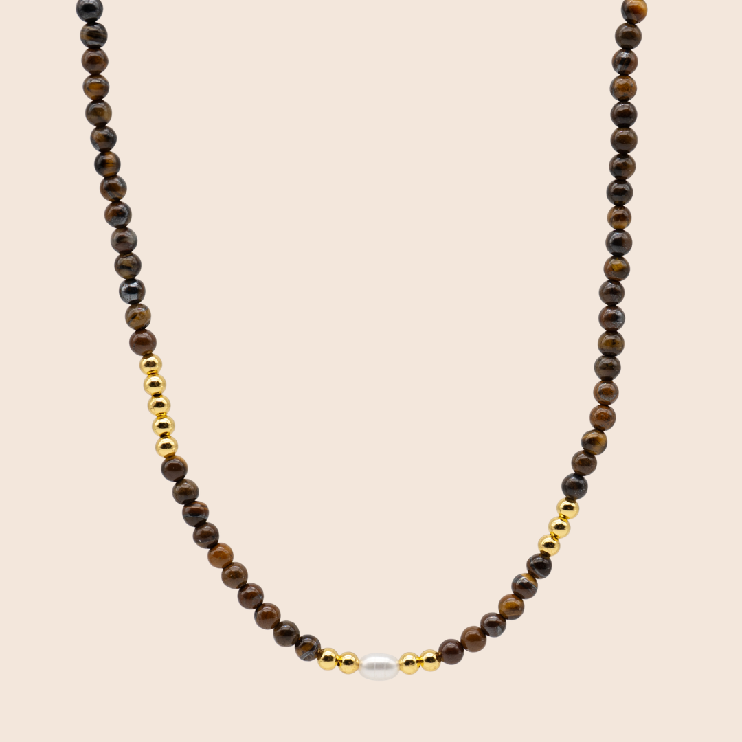 Necklace with brown beads and a gold accent on a beige background