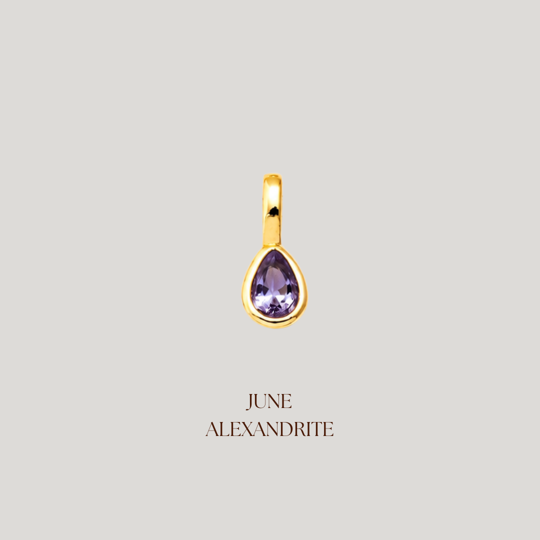 Gold pendant with a purple gemstone on a light gray background
