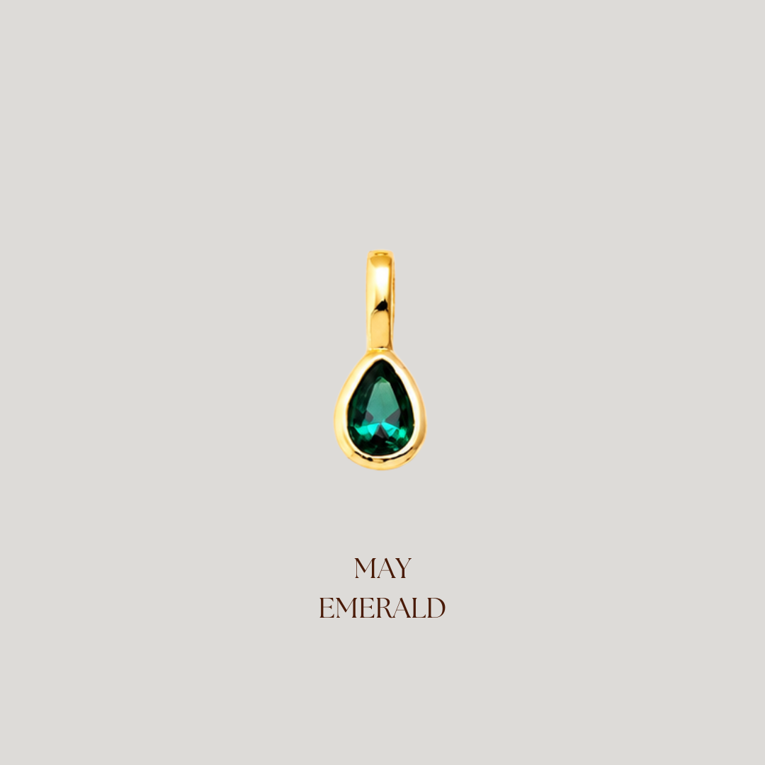 Gold pendant with a green gemstone on a light gray background, labeled 'May Emerald'.