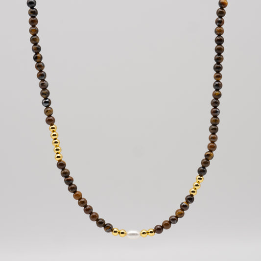 Necklace with brown beads and gold accents on a gray background