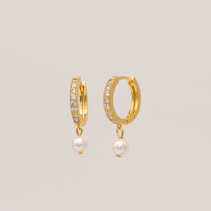 A pair of gold-plated hoop earrings with cubic zirconia stones and pearl accents.